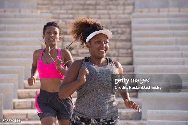 dos mujeres gordas y delgadas corriendo al aire libre. - fat fotografías e imágenes de stock