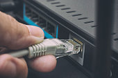 Person plugging in cable to wireless router