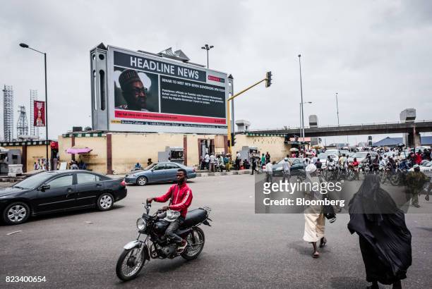 Giant electronic advertising screen displays headline news about Muhammadu Buhari, Nigeria's president, to pedestrians in Lagos, Nigeria, on...
