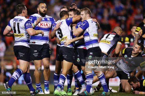 Josh Reynolds of the Bulldogs celebrates with team mates after scoring a try during the round 21 NRL match between the Penrith Panthers and the...