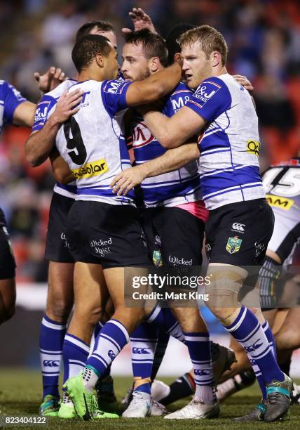 Josh Reynolds of the Bulldogs celebrates with team mates after scoring a try during the round 21 NRL match between the Penrith Panthers and the...