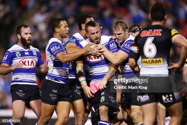 Josh Reynolds of the Bulldogs celebrates with team mates after scoring a try during the round 21 NRL match between the Penrith Panthers and the...