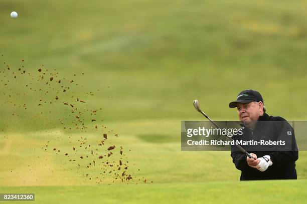 Andrew Oldcorn of Scotland hits from a bunker on the 4th hole during the first round of the the Senior Open Championship presented by Rolex at Royal...