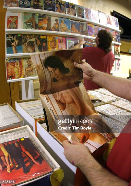 Visitor looks at a centerfold of an older Playboy magazine April 7, 2001 at the Vintage And Modern Pinup Show in Rosemont, IL. The V.A.M.P. Is a...