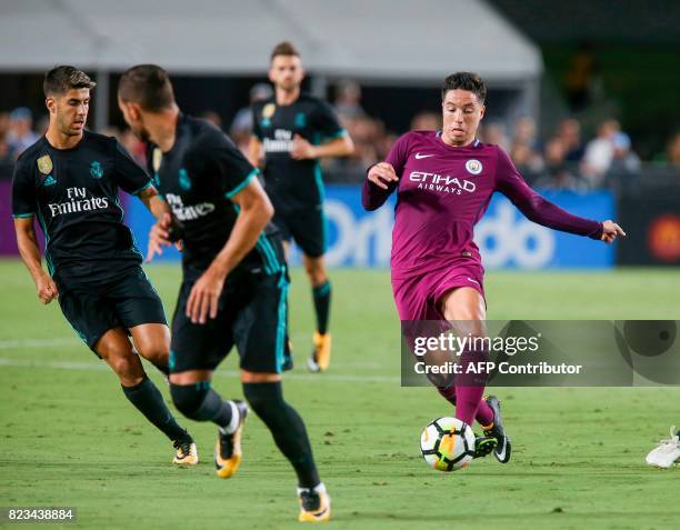 Manchester City midfielder Samir Nasri, right, drives the ball against Real Madrid during the second half of the International Champions Cup match on...