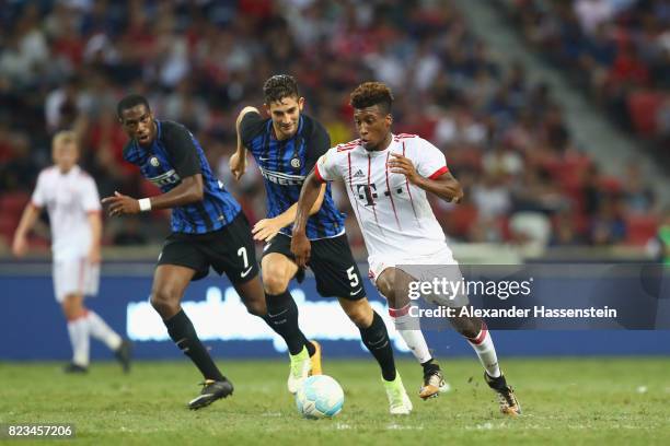 Kingsley Coman of Bayern Muenchen battles for the ball with Geoffrey Kondogbia of Inter and his team mate Roberto Gaglairdini during the...