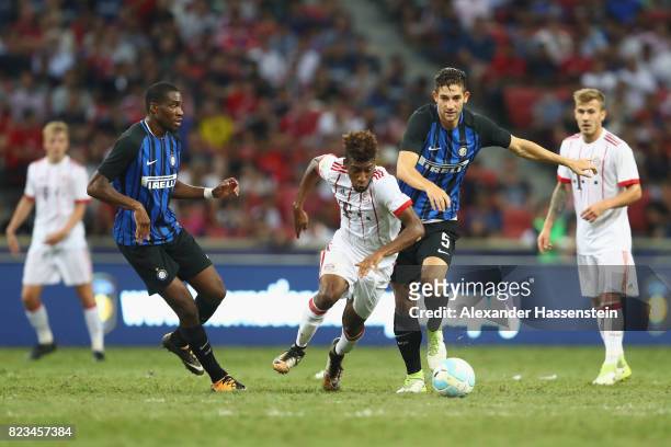 Kingsley Coman of Bayern Muenchen battles for the ball with Geoffrey Kondogbia of Inter and his team mate Roberto Gaglairdini during the...