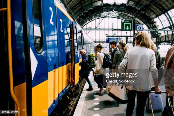 friends catching the train in amsterdam - railroad station stock pictures, royalty-free photos & images