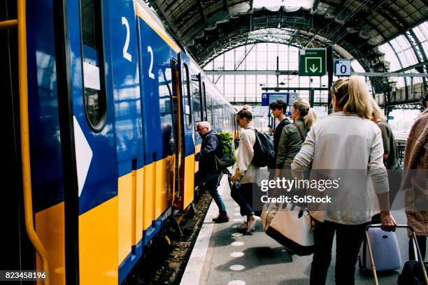 friends catching the train in amsterdam - railroad station platform stock pictures, royalty-free photos & images