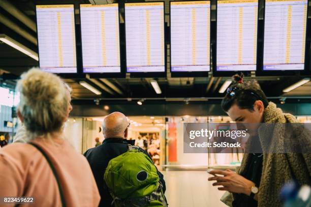 friends at the airport in amsterdam - arrival board stock pictures, royalty-free photos & images