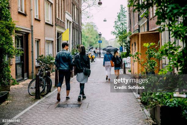 vrienden wandelen in amsterdam - amsterdam canal stockfoto's en -beelden