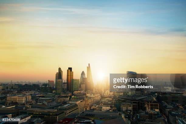 view of the city of london finance district with sun - london sunrise stock pictures, royalty-free photos & images