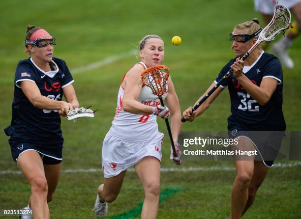 Malgorzata Kacperczyk of Poland is challenged by Ally Carey and Michelle Tumolo of the United States during the Lacrosse Women's match between USA...