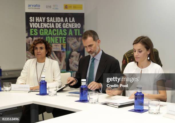 King Felipe VI of Spain and Queen Letizia sit with Minister of Health, Dolors Montserrat, during a visit to the offices of the 016 Telefonic hotline...