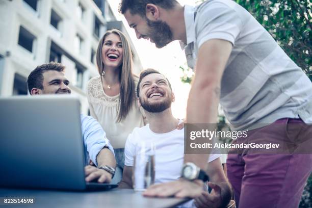 groupe d’amis fous je regarde la vidéo drôle et s’amuser dans un café restaurant - taquiner photos et images de collection