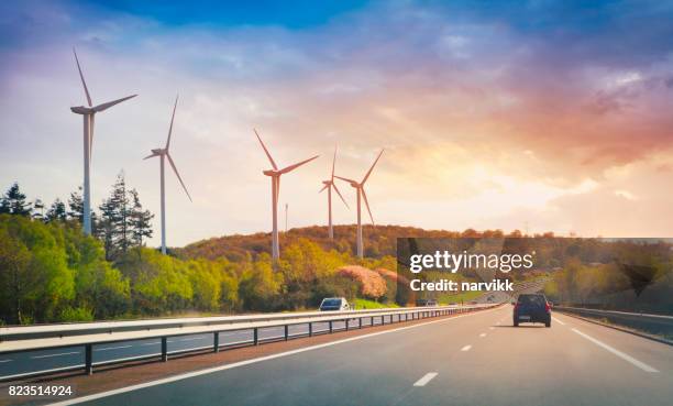 highway and wind turbines - car road sunset stock pictures, royalty-free photos & images