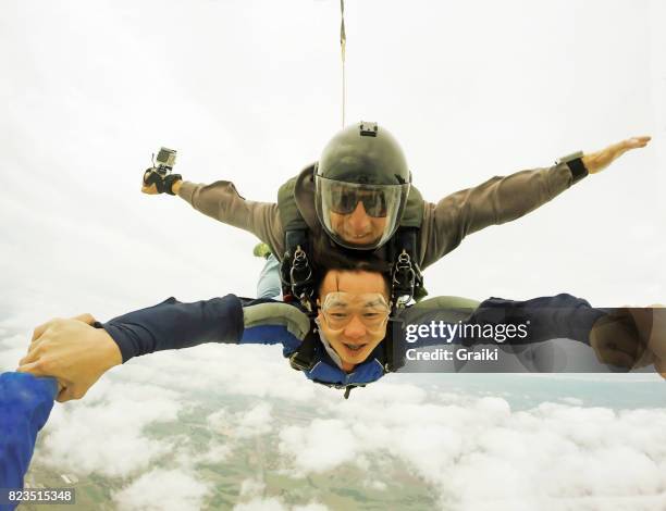 skydiving tandem asian man - skydiving pov stock pictures, royalty-free photos & images