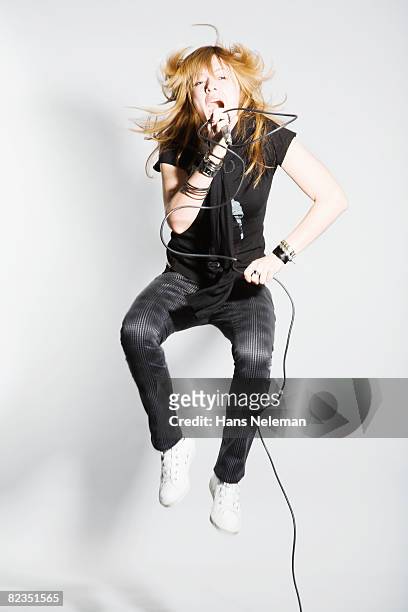 young woman holding a microphone and singing, moscow, russia  - blonde female singers stock-fotos und bilder