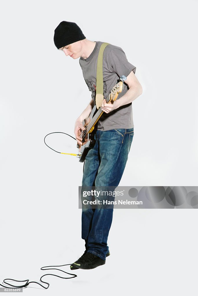 Side profile of a young man playing a guitar, Moscow, Russia