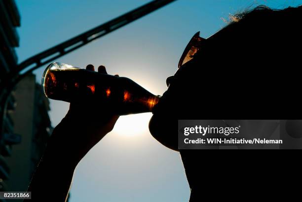 silhouette of a woman drinking soda, buenos aires, argentina - soda photos et images de collection