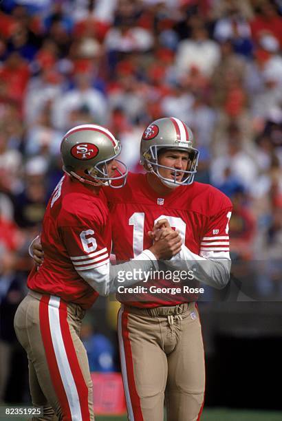 Punter/holder Mike Cofer congratulates teammate kicker Klaus Wilmsmeyer of the San Francisco 49ers during a game against the Minnesota Vikings at...