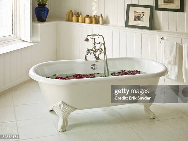 a water-filled bathtub with flower petals - verwöhnen stock-fotos und bilder