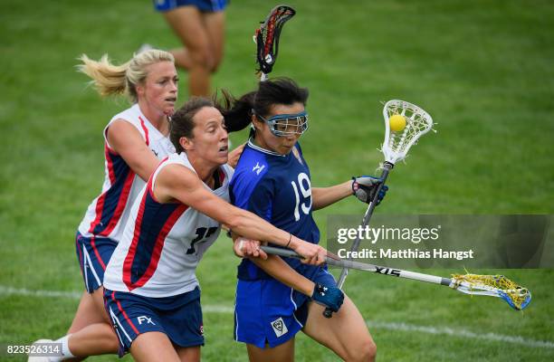 Sachiko Komine of Japan is challenged by Sophie Whitehead and Olivia Wimpenny of Great Britain during the Lacrosse Women's match between Great...