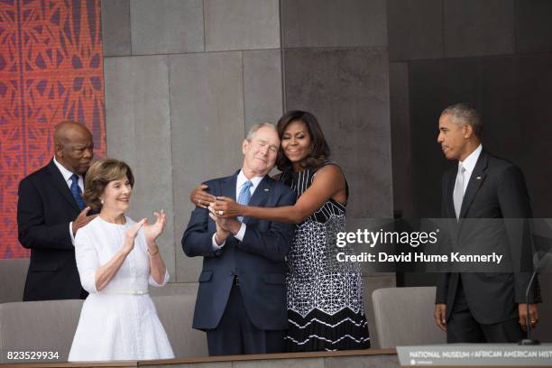 First Lady Michelle Obama hugs former President George W Bush at the opening of the National Museum of African American History and Culture,...