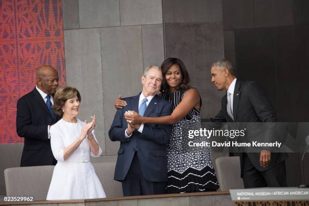 First Lady Michelle Obama hugs former President George W Bush at the opening of the National Museum of African American History and Culture,...