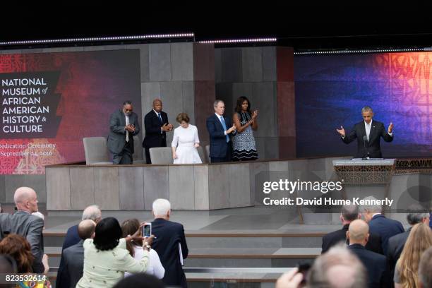 President Barack Obama gestures as he receives a standing ovation at the opening of the National Museum of African American History and Culture,...