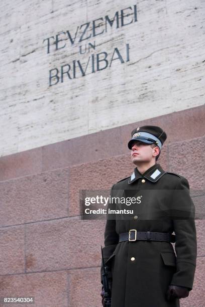 guardia de honor custodiando el monumento a la libertad - bandera de letonia fotografías e imágenes de stock