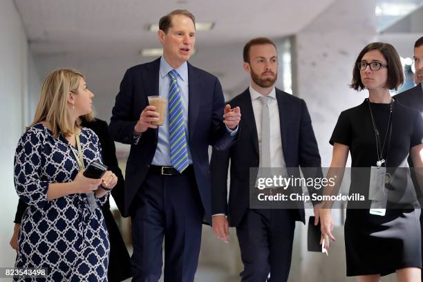 Sen. Ron Wyden talks with staff members as he heads to a closed-door meeing of the Senate Intelligence Committee in the Hart Senate Office Building...