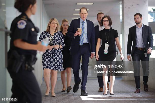 Sen. Ron Wyden talks with staff members as he heads to a closed-door meeing of the Senate Intelligence Committee in the Hart Senate Office Building...