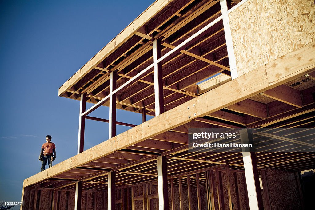 Man standing on house under construction