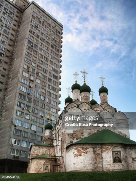 architectural contrasts: towering socialist housing project against old orthodox church in moscow, russia - anticommunist stock pictures, royalty-free photos & images