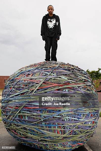 Joel Waul poses for a photograph with the 8,200 pound rubber band ball that he created in the driveway of his home August 14, 2008 in Lauderhill,...