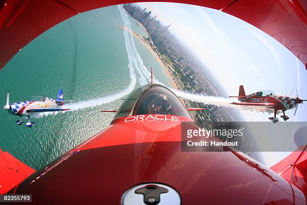Pilot Sean Tucker , his son Eric and Ben Freelove fly their aircraft over Lake Michigan as they prepare for this weekend's Chicago Air and Water Show...