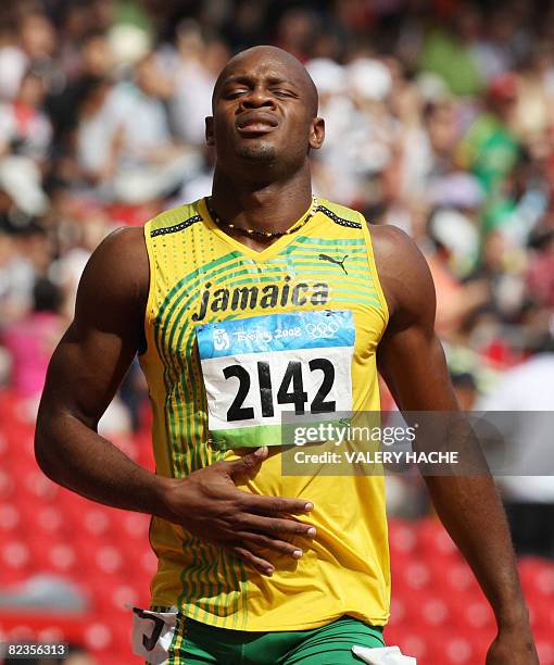 Jamaica's Asafa Powell crosses the finish line during the men's first round 100m heat 1 at the "Bird's Nest" National Stadium as part of the 2008...