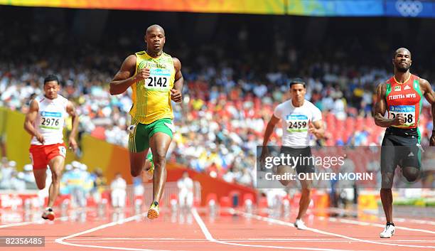 Tonga's Aisea Tohi, Jamaica's Asafa Powell, Marshall Island's Roman William Cress and Saint Kitts and Nevis' Kim Collins compete during the men's...