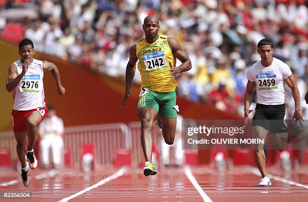 Tonga's Aisea Tohi, Jamaica's Asafa Powell and Marshall Island's Roman William Cress compete during the men's first round 100m heat 2 at the "Bird's...