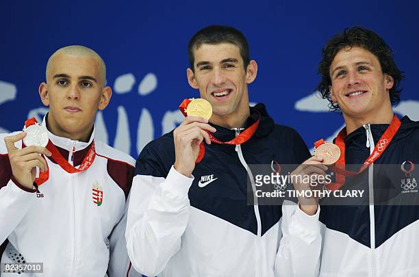 Gold medalist US swimmer Michael Phelps , silver medalist Hungarian Laszlo Cseh and bronze medalist US swimmer Ryan Lochte stand on the podium for...