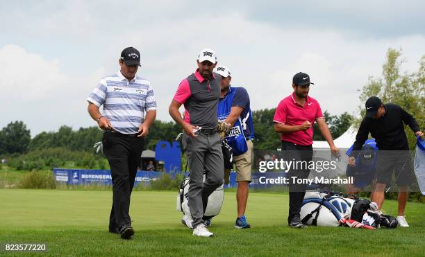 Patrick Reed of the United States, Charl Schwartzel of South Africa and Alexander Levy of France leave the 9th green after finishing their first...