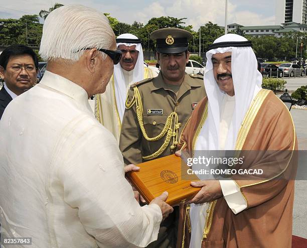 Manila Mayor Alfredo Lim hands a gift to Kuwait's Prime Minister, Sheikh Nasser Mohammed al-Ahmed al-Sabah after the wreath laying ceremony at the...