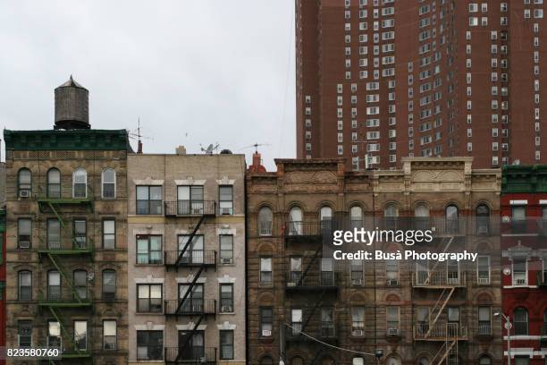 tenement houses in chinatown, with tall skyscraper in the background. new york city, usa - lower east side manhattan stock pictures, royalty-free photos & images