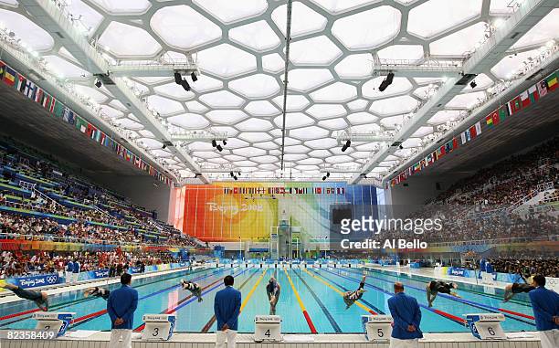 The competitors dive into the water at the start of the second Men's 50m Freestyle Semifinal held at the National Aquatics Centre during Day 7 of the...