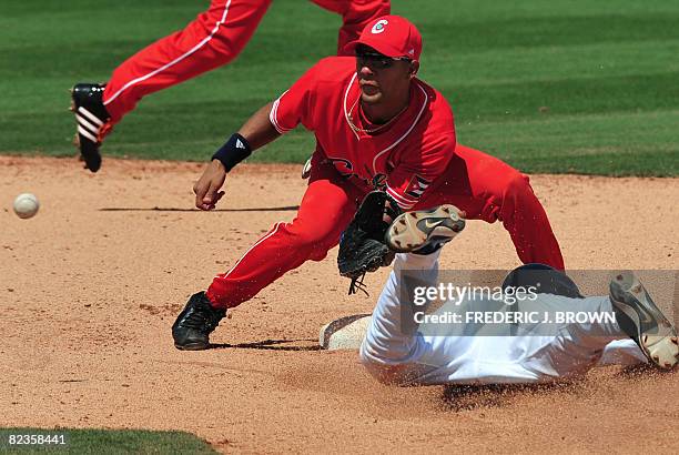 Cuba's Yuliesky Gurriel awaits the ball ahead on a sliding Jason Donald of the US who was ruled out in their men's preliminary baseball game at the...