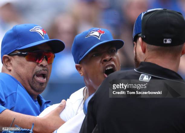Marcus Stroman of the Toronto Blue Jays argues with home plate umpire Will Little as he is restrained by bench coach DeMarlo Hale after being ejected...