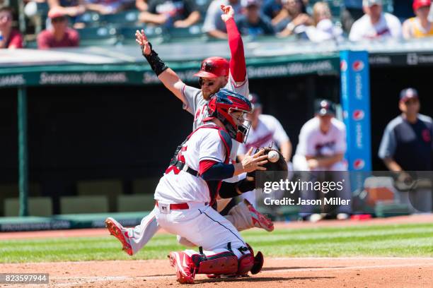 Catcher Roberto Perez of the Cleveland Indians makes the catch as Kole Calhoun of the Los Angeles Angels of Anaheim scores to tie the game during the...