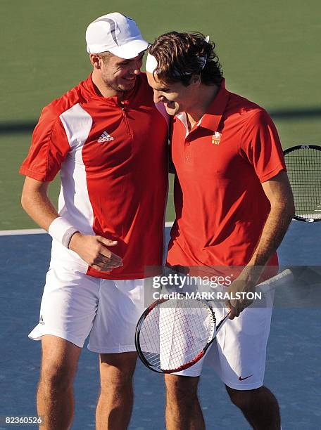 Roger Federer of Switzerland is hugged by his partner and compatriot Stanislas Wawrinka after winning their men's doubles quarter-final against...