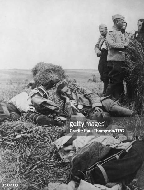 French gendarme and his German prisoner sleep side by side on a haystack during World War I, circa 1916.